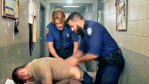 Two cops in uniform frisking and exposing suspect's buttocks in hallway