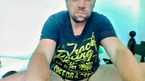 Amateur guy in blue Speed Glory t-shirt spreads legs on cam
