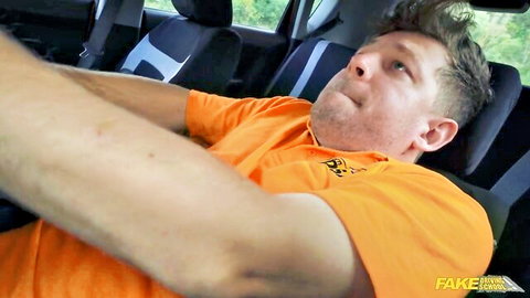 Redhead Fake Taxi driver in orange shirt sits surprised in car seat
