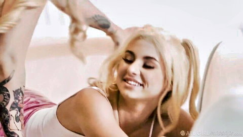 Tattooed man grabs blonde pigtail girl's hair pulling her head back as she smiles teasingly in tank top