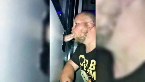 Ginger bearded man sucking cock through gloryhole wall
