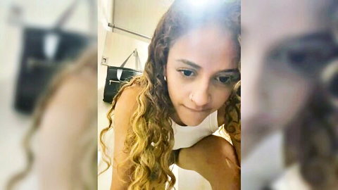 Alana15 petite Latina with curly blonde hair in seductive upskirt pose