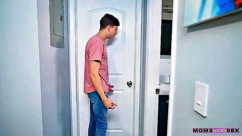 Young stepson in jeans and t-shirt at bathroom door in taboo stepmom scene
