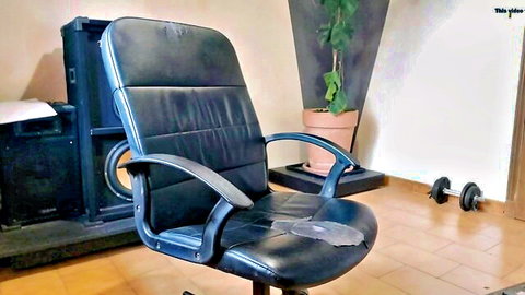 Worn black leather office chair with armrests in casual room setting