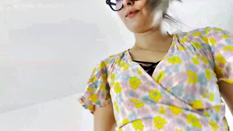 Seductive Indian stepmom in floral wrap dress smirking teasingly