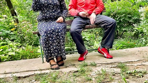 Curvy cuckold wife in floral dress sits with hubby on outdoor bench