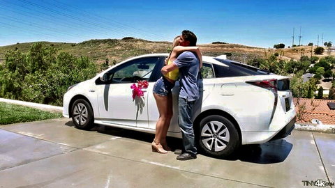 Sexy young brunette teen in tiny daisy duke shorts hugs boyfriend next to new white Prius car