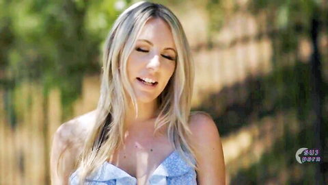 Blonde Caitlin Bell smiling in blue dress, Aria Taylor lesbian sex scene