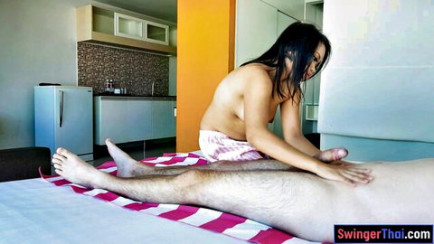 Topless petite Thai masseuse stroking naked man's cock in erotic happy ending massage