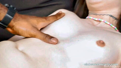 Black hand groping and squeezing pale white girl's small exposed tit closeup