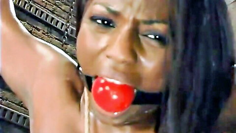 Ebony MILF gagged with red ball gag in intense BDSM bondage closeup