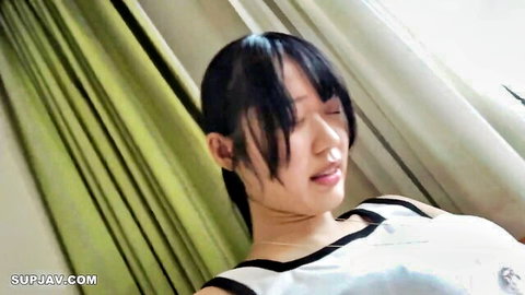 Seductive Asian babe with small tits teasing in low-cut white top on bed