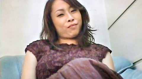 Sexy Japanese woman with big natural tits pouting seductively in tight top on couch