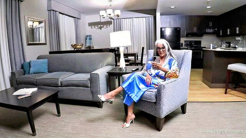 Naughty granny in blue robe holding phone seductively