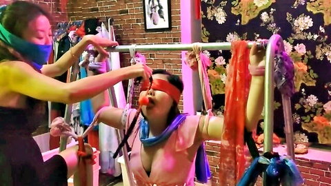 Two Asian women in lesbian BDSM bondage with blindfold and ball gag