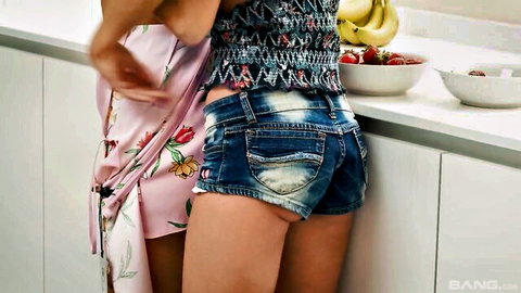 Two hot girls in kitchen, one bent over counter in tiny frayed denim shorts as other grinds hips against her ass