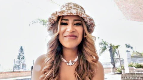 Mila Milkshake smiling topless in bucket hat poolside