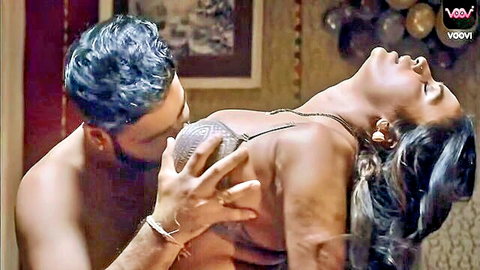 Shirtless Indian man gropes massive exposed tits of moaning brunette woman with head thrown back in ecstasy