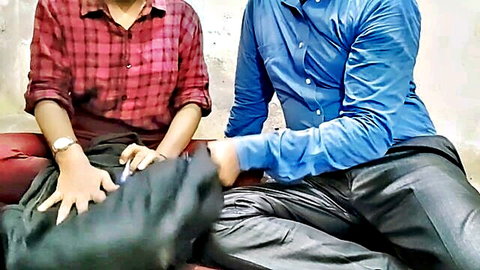 South Asian girl in red plaid shirt gropes guy's cock through black pants on bed