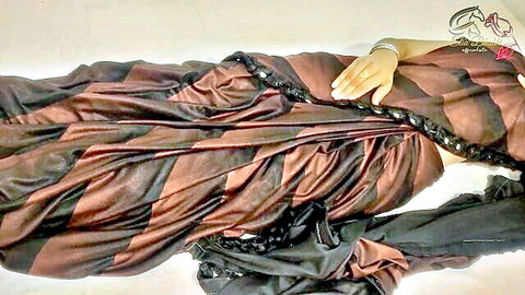 Seductive South Asian housewife lying on bed in sheer striped saree exposing curves and cleavage