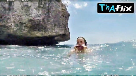Allison Miller in wet bikini, nibbling watermelon in ocean waves