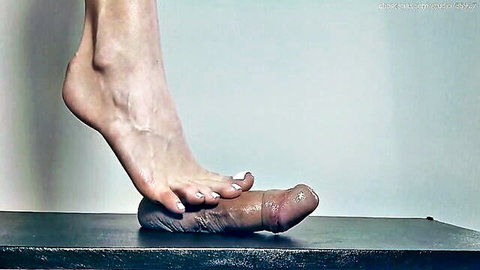 Bare foot with white toenails gripping and stroking thick shiny lubed cock in amateur footjob.