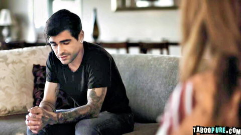 Scarlett Mae from behind with tattooed man on couch, intimate adult scene