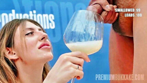 Brunette caucasian woman holds glass of cum, ready to swallow in bukkake scene