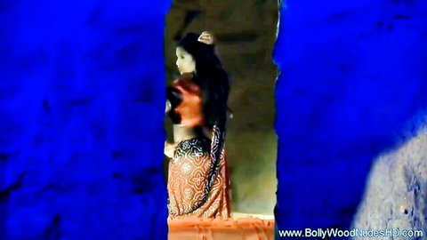 Sexy Indian brunette babe in orange saree teasing with exposed midriff and curves