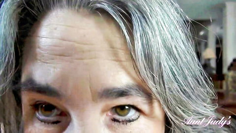 Silver-haired mature Aunt Judy close-up POV with hazel eyes and wrinkles gazing seductively