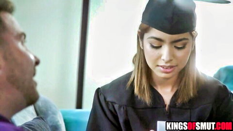 Brunette teen in graduation cap and gown seduces older man on couch