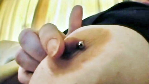Close-up of BBW's large pale breast with nipple piercing touched by hand