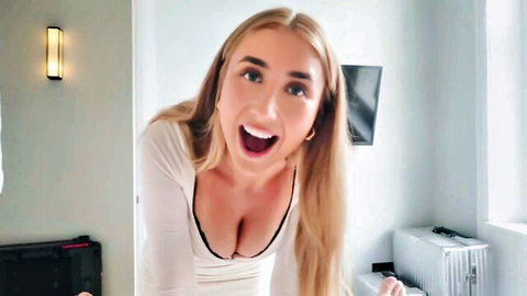 Excited busty blonde babe smiling wide with huge tits cleavage in low-cut top