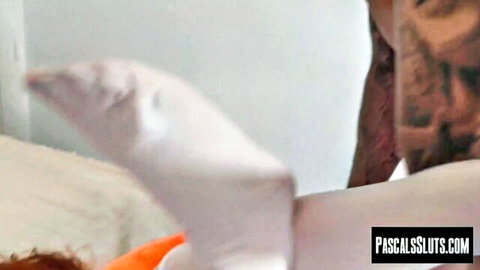 Pale-skinned curvy babe submissive on bed with man grabbing her leg in rough BDSM play