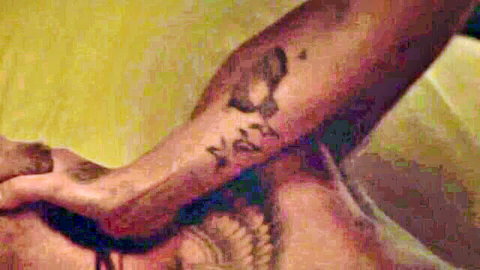 Tattooed woman's hand gripping thick veiny black cock in closeup handjob