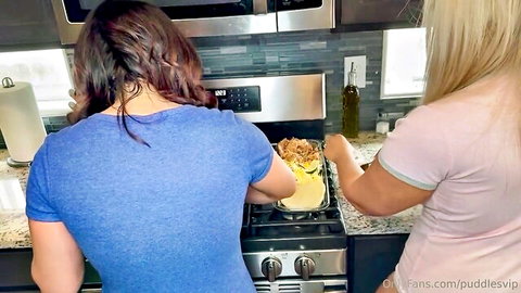 Two naughty housewives in tight shirts cooking on stove bending over kitchen counter