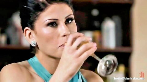 Seductive brunette lawyer in teal dress sipping champagne before domination