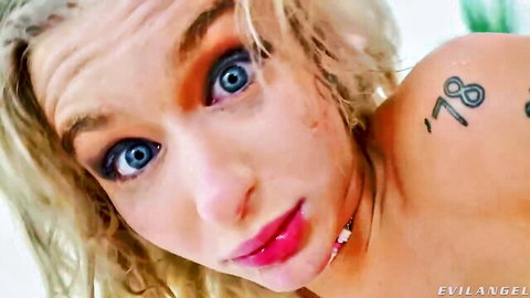 Blonde Emma Rosie topless close-up with blue eyes and messy hair