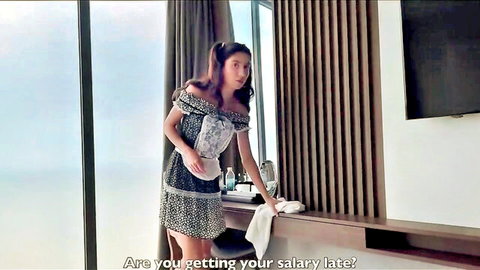 Lustful Asian teen in short off-shoulder dress posing seductively by window