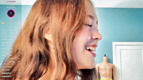 Redhead camgirl smiles teasingly in solo webcam stream with mannequin backdrop
