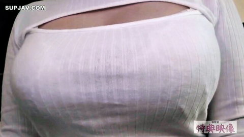 Asian woman with large exposed breasts in cut-out white sweater by window