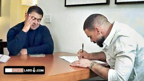 Muscular bearded boss in white shirt signs contract as older man watches intently