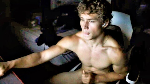 Curly-haired muscular guy strokes his hard cock naked in gaming chair on webcam