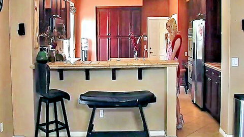 Blonde in red dress teasing reveal underneath in kitchen