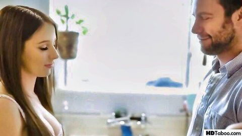 Brunette with deep cleavage embraced by bearded man in intimate kitchen moment