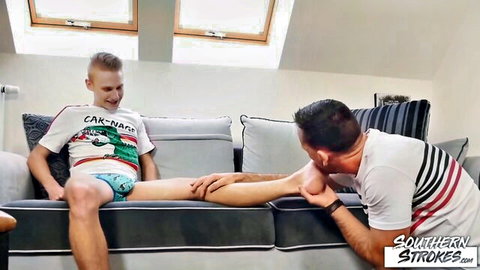 Stepdad massages young stepson's leg in underwear on couch