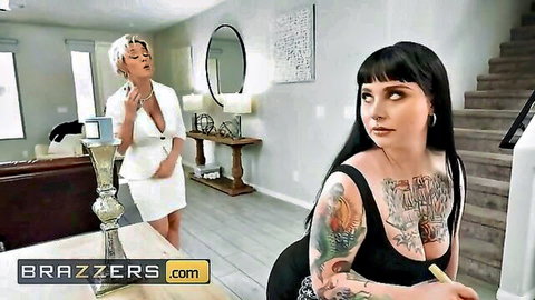 Dee Williams in white suit teases tattooed Olivia Vee on couch
