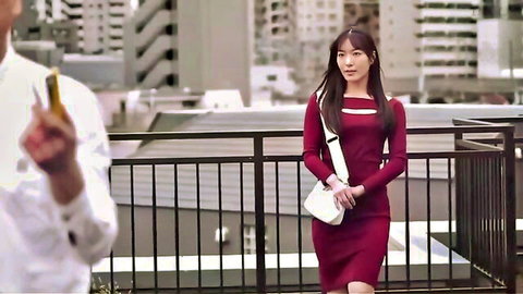 Stunning Asian woman in tight red dress on urban balcony with suited man