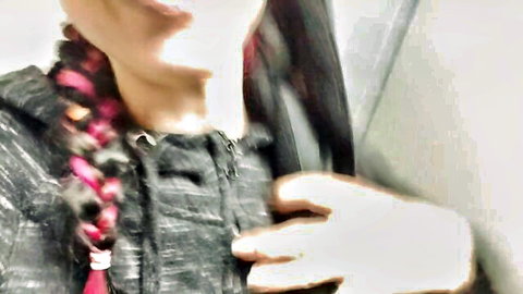 Blurry woman with pink braid in hoodie fingering in theater restroom