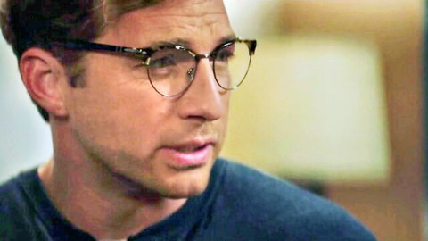 Handsome young man in glasses and blue shirt looking sideways closeup